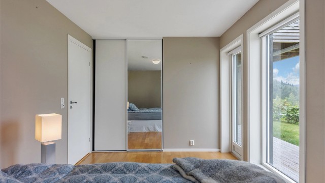 En stor skyvedørsgarderobe med speilfronter gir rikelig med oppbevaringsplass.