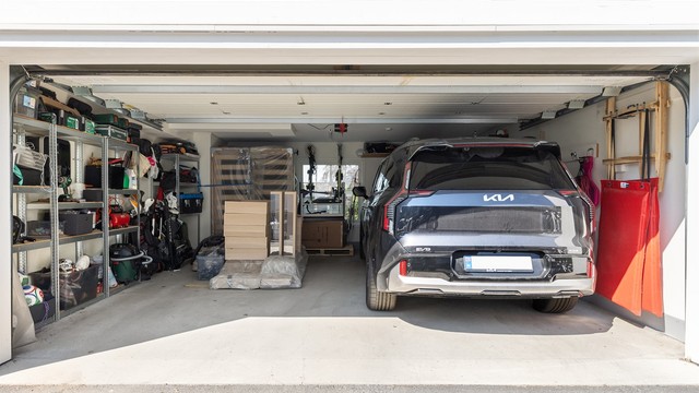 Integrert dobbeltgarasje med elektrisk portåpner og montert elbillader.