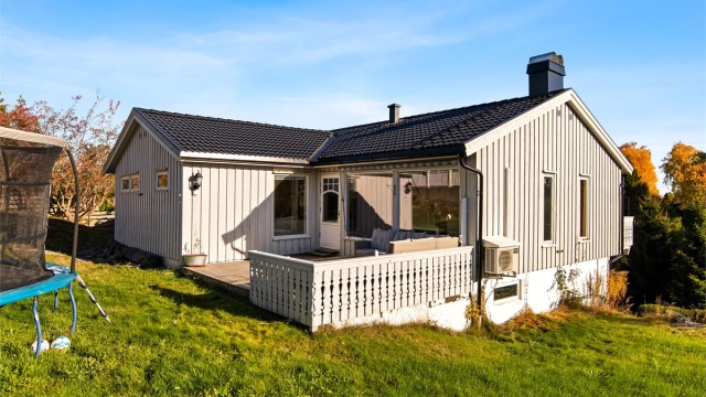 Eiendommen har en romslig hage med gressplen og naturtomt på baksiden.
