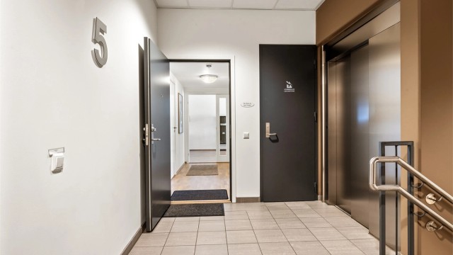 Heis- og trappeadkomst til leilighetens etasjeplan (5. etasje), heisen er rett ved inngangen til leiligheten.