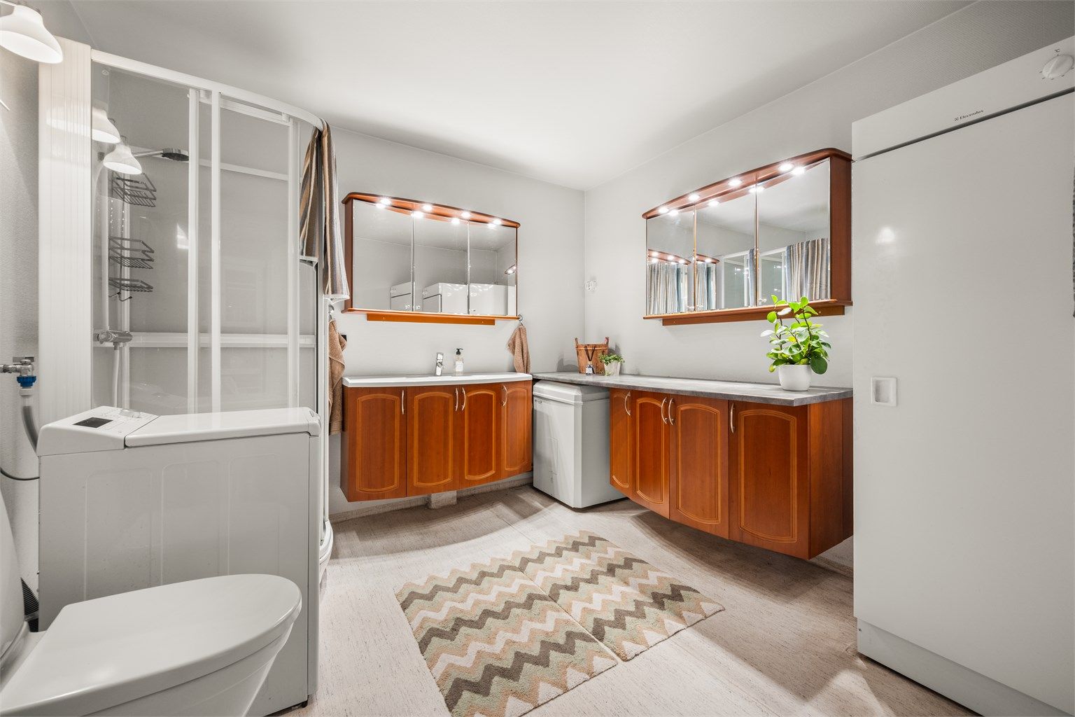 Romslig bad med gulvvarme, dusjkabinett og opplegg for vaskemaskin.