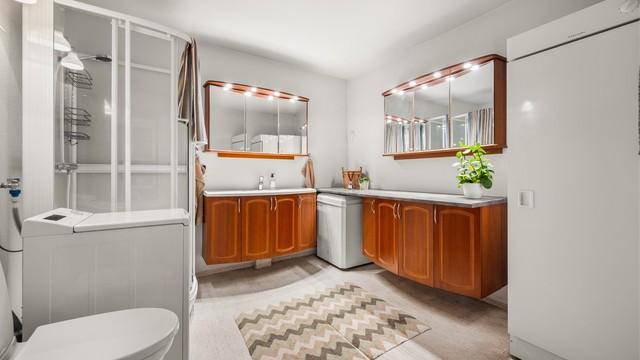 Romslig bad med gulvvarme, dusjkabinett og opplegg for vaskemaskin.