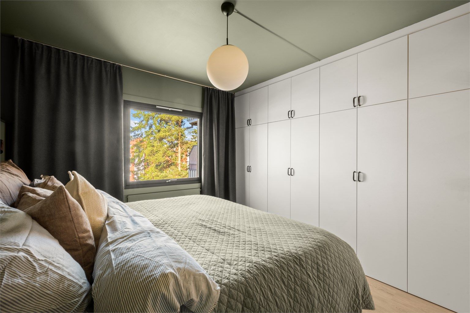 En hel vegg med garderobeskap gir rikelig med oppbevaringsplass.