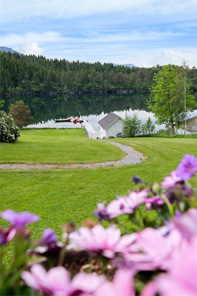 En sjarmerende sti slynger seg gjennom hagen ned mot naustet og bryggen