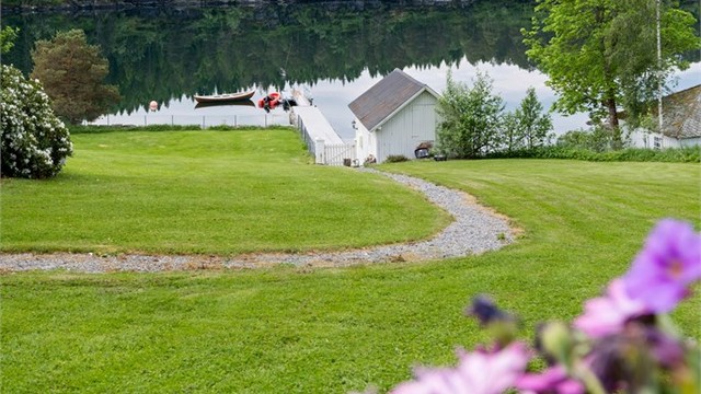 En sjarmerende sti slynger seg gjennom hagen ned mot naustet og bryggen