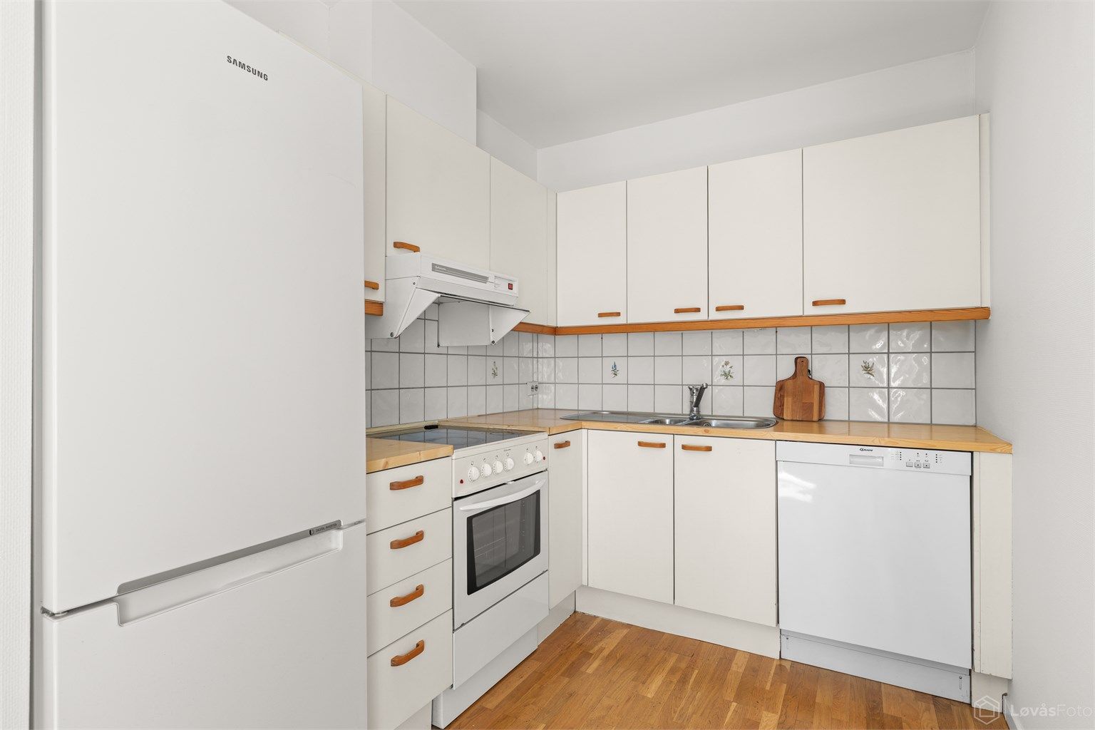 Kjøkkenet har åpen løsning mot spisestuen og fremstår funksjonelt med innredning med glatte fronter og laminert benkeplate. 