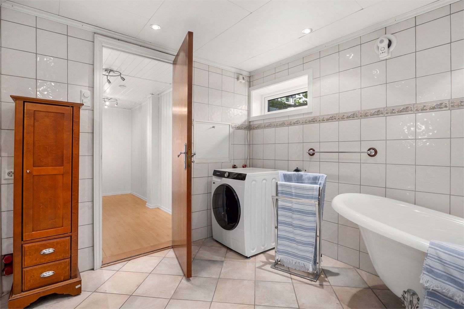 Romslig bad med badekar og opplegg for vaskemaskin.