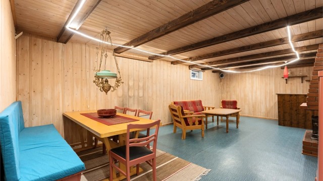 Romslig kjellerstue med plass til både sittegruppe og spisebord.