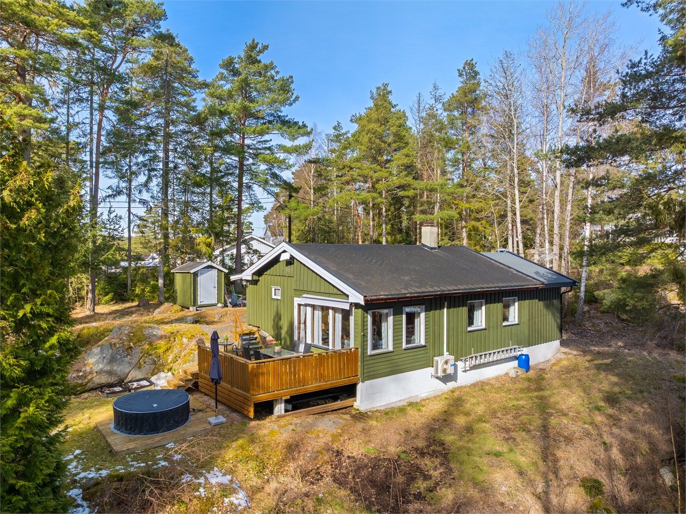 Omgitt av skjermende løv- og nåletrær ligger hytta i Ilebukta 28, oppført i 1977 og tilbygget i 2014.