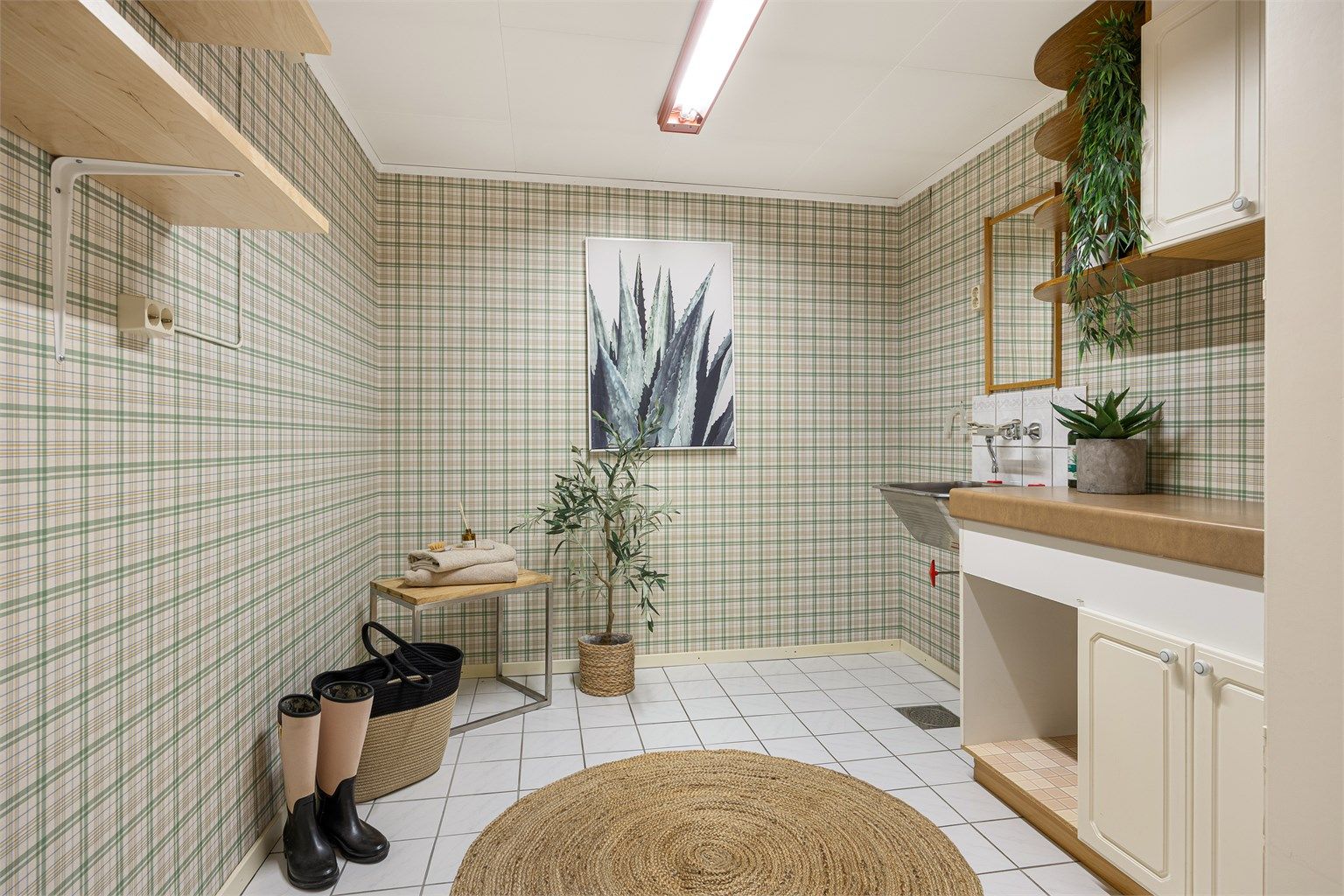 Romslig vaskerom med flislagt gulv med gulvvarme og opplegg for vaskemaskin.