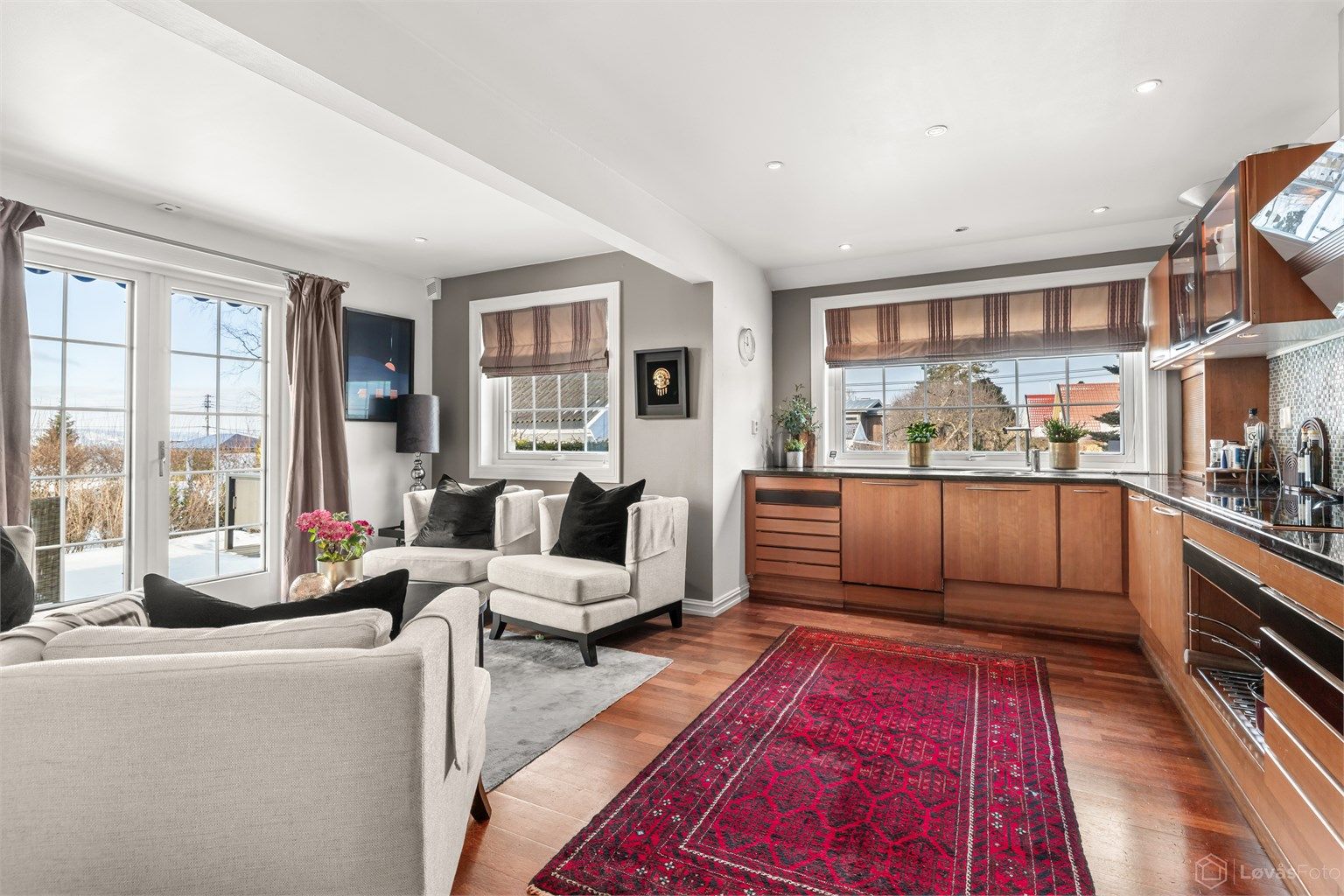 Romslig og hyggelig kjøkken med peis og utgang til terrassen og hagen via 2-fløyet terrassedør