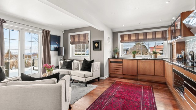 Romslig og hyggelig kjøkken med peis og utgang til terrassen og hagen via 2-fløyet terrassedør