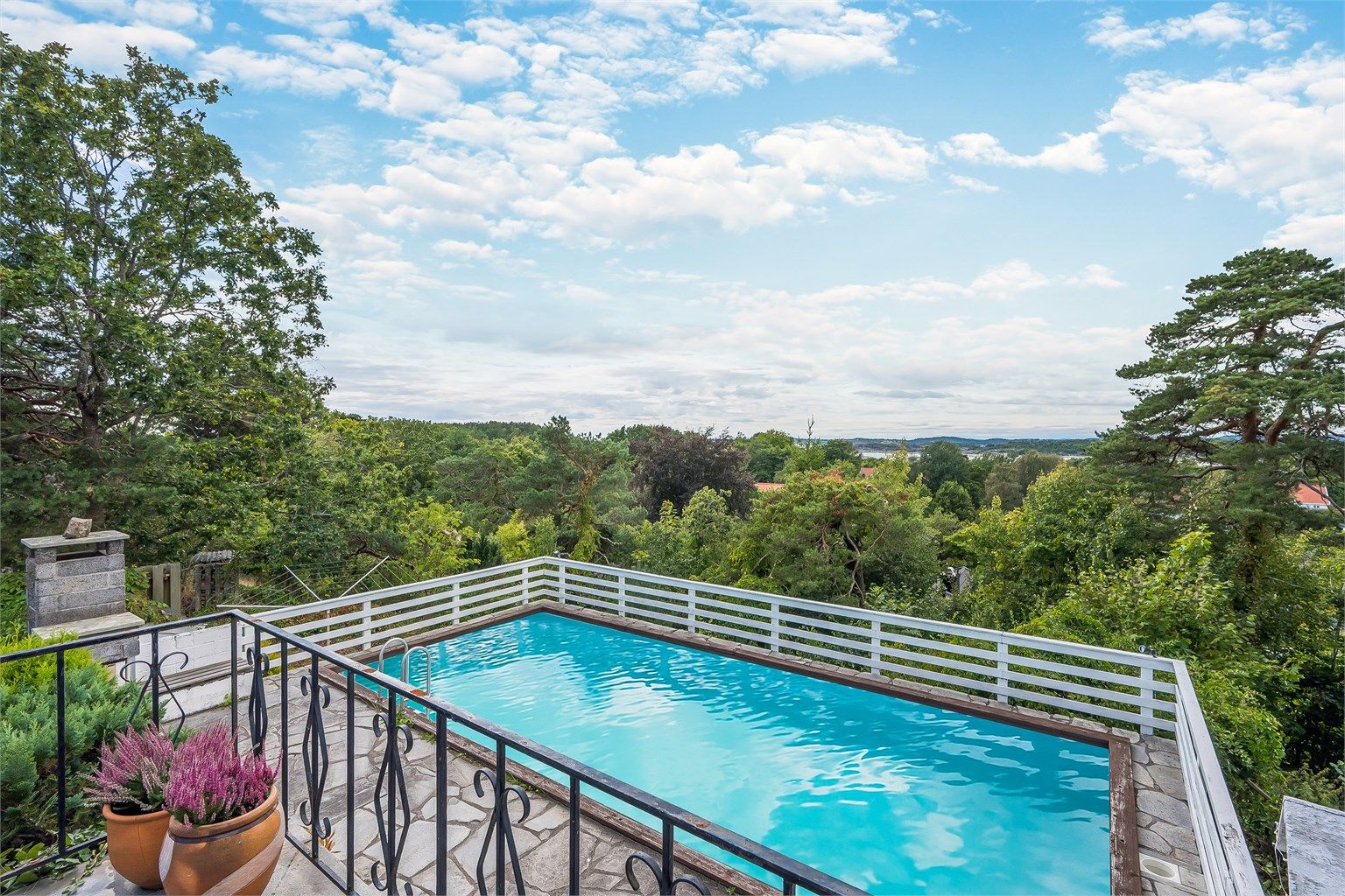 I front har eiendommen en herlig, usjenert skiferterrasse med god plass til utemøbler. Her har også eiendommen et stort svømmebassang som en gang i tiden har vært et eldorado for hele familien