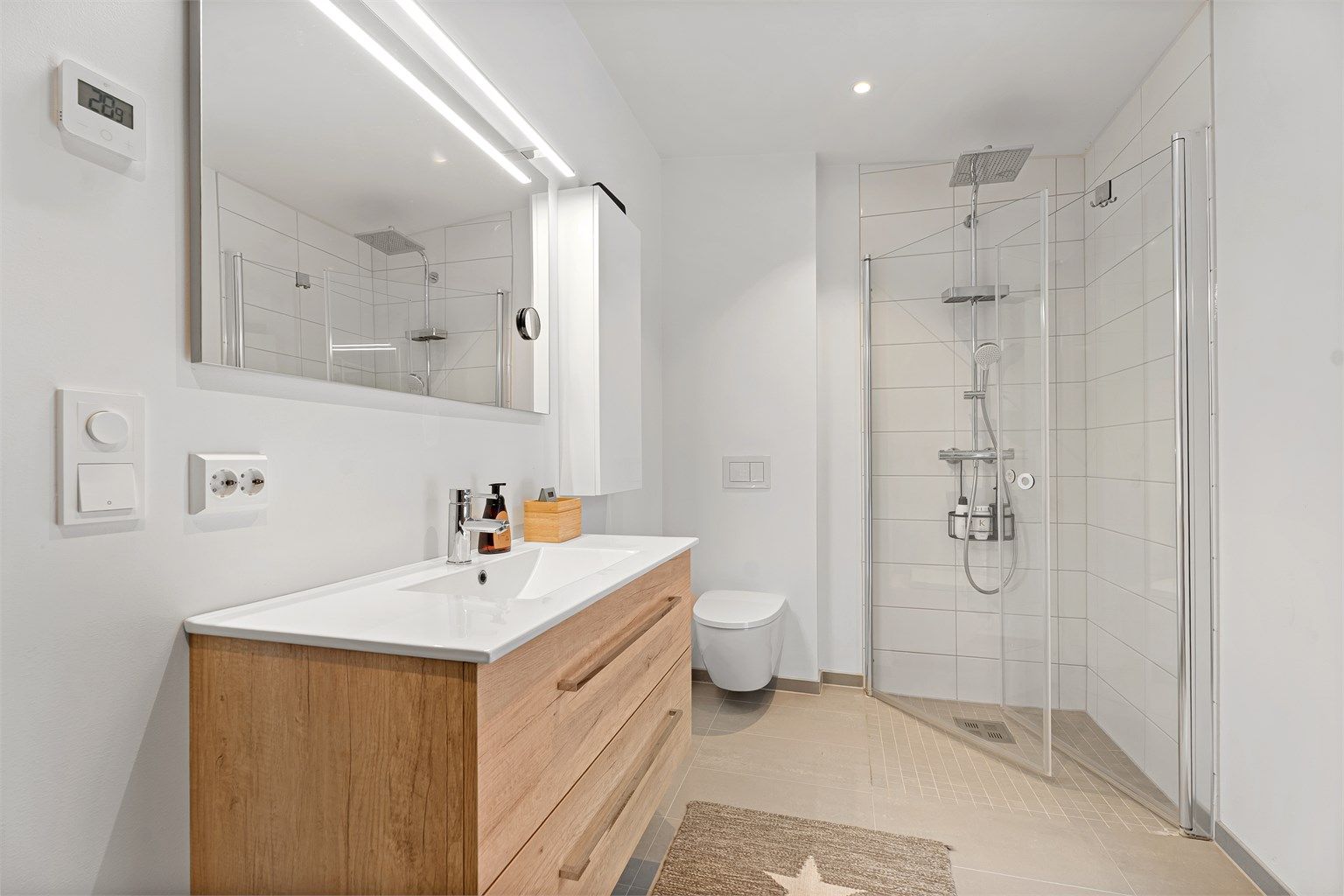 Flott bad med flislagt gulv og flislagte vegger i dusjsone og baderomsinnredning fra AUBO, i boligens andre etasje