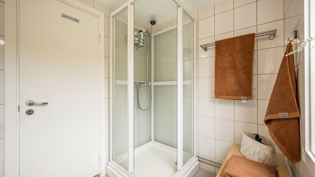 Baderommet har flislagte vegger og flislagt gulv med varmekabler. Dusjkabinett, servant samt under- og overskap ble skiftet i 2016.