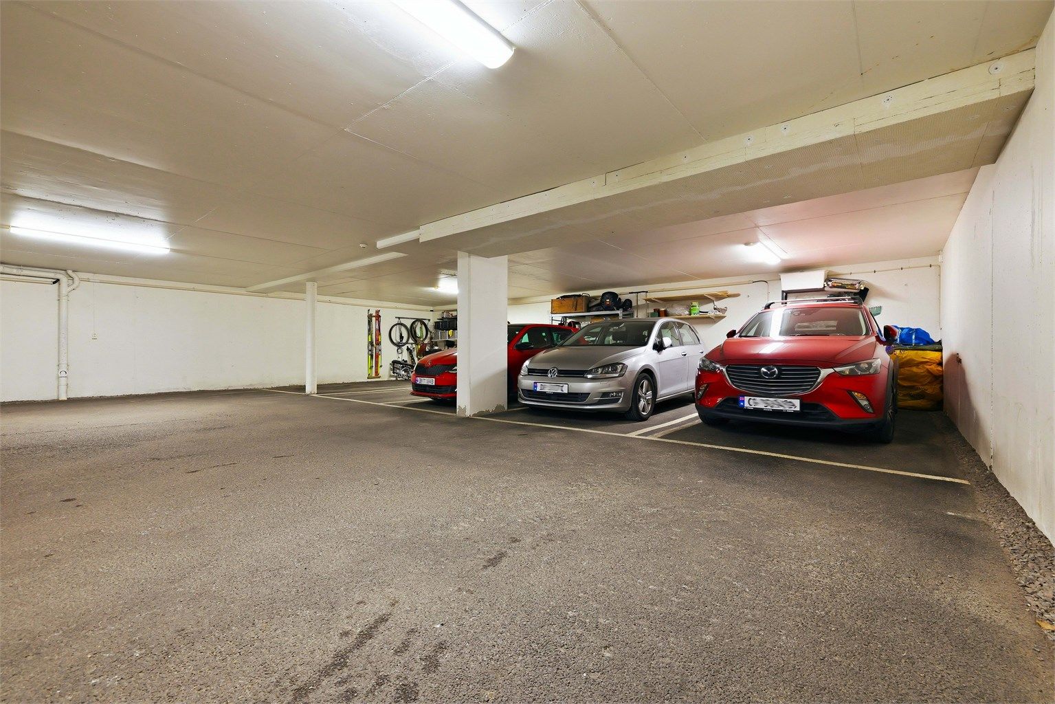 Egen garasjeplass i oppvarmet og avlåst garasjekjeller. Det er plassen der den sølvgrå bilen står parkert som tilhører leiligheten. Det er mulighet for å etablere el-bil lader på parkeringsplassen