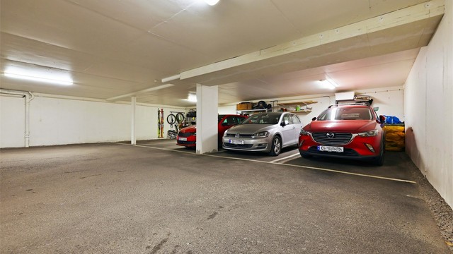 Egen garasjeplass i oppvarmet og avlåst garasjekjeller. Det er plassen der den sølvgrå bilen står parkert som tilhører leiligheten. Det er mulighet for å etablere el-bil lader på parkeringsplassen