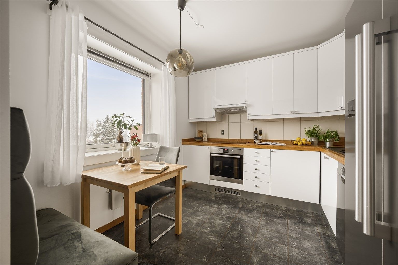 Stilrent og nøytralt kjøkken med glatte fronter og benkeplate i heltre. Ingen innsyn!