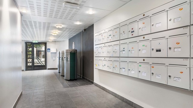 Felles inngangsparti med postkasser og adkomst fra bakkeplan.