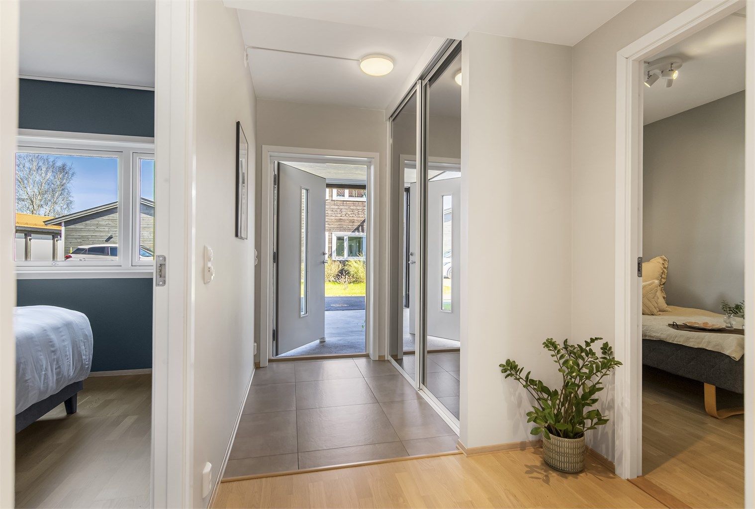 Entréen har flislagt gulv med gulvvarme og en romslig skyvedørsgarderobe med speilfronter.