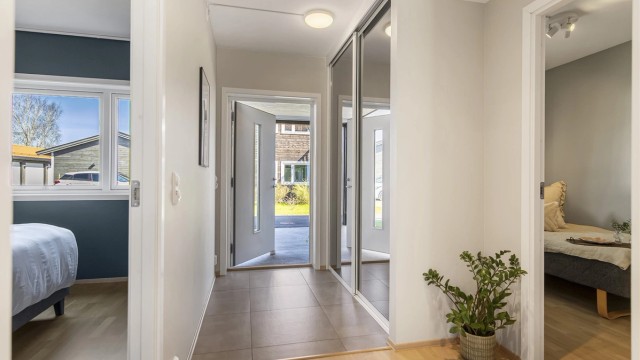 Entréen har flislagt gulv med gulvvarme og en romslig skyvedørsgarderobe med speilfronter.