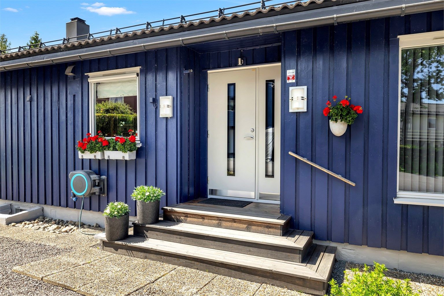 Pent og innbydende inngangsparti med trapp i treverk. Området er opparbeidet med heller og har god plass til både blomster og en sittebenk – en hyggelig og hjemmekoselig velkomst til boligen.