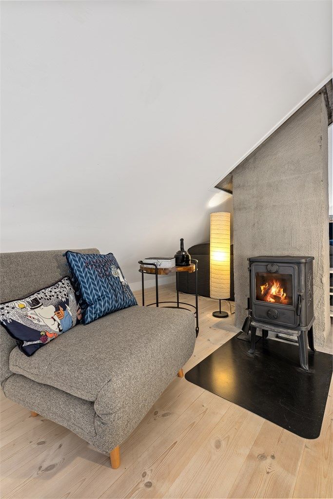 Peisovn med glassfront gir lun varme og ekstra hygge på loftet.
