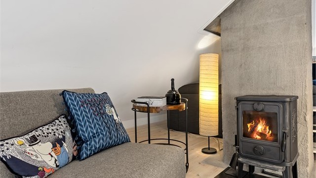Peisovn med glassfront gir lun varme og ekstra hygge på loftet.
