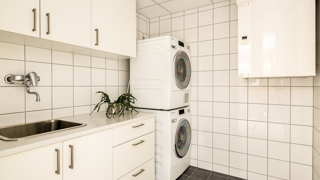 Eget praktisk vaskerom. Her er det godt med skapplass og opplegg for både vaskemaskin og tørketrommel.