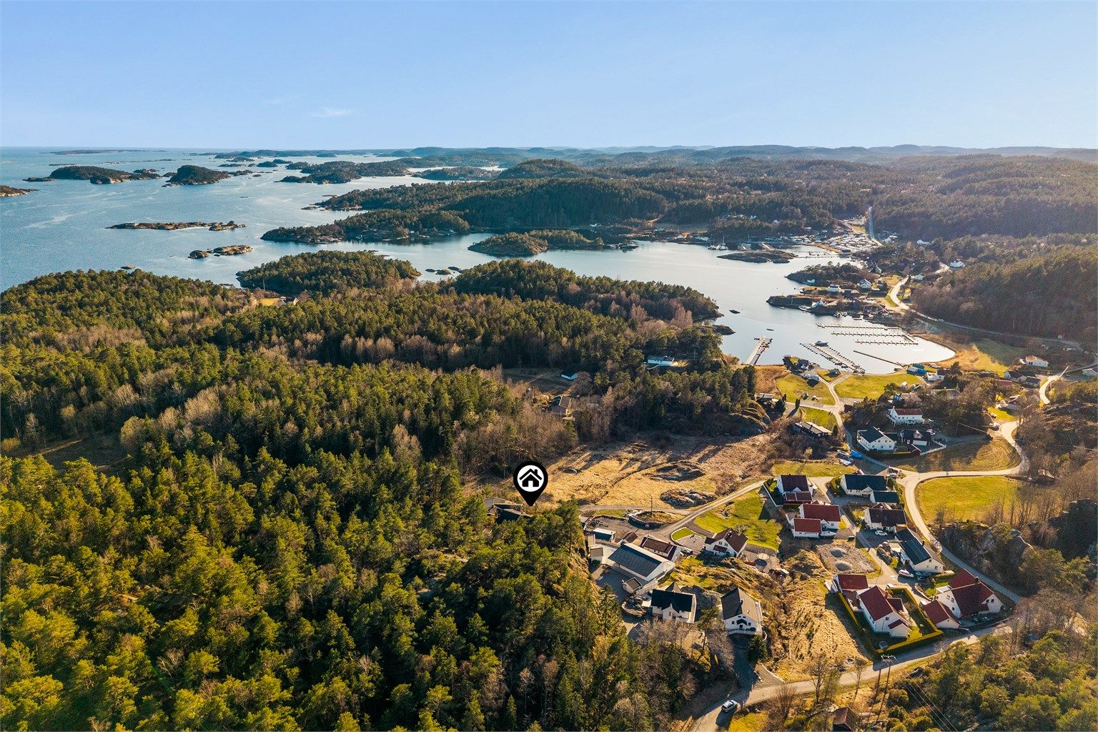Hytta ligger på en voll med skog i bakkant med gamle, høyreiste furutrær. Stiene går på kryss og tvers gjennom skogbunn og fører til en kyststi.