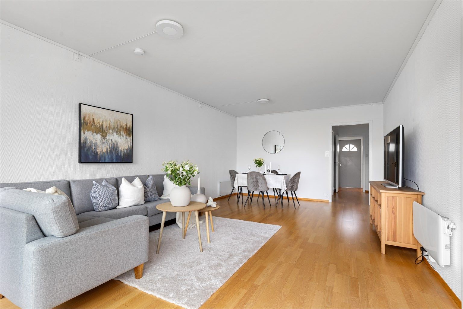 Leiligheten har en romslig stue og har plass til både sofagruppe og spisebord.