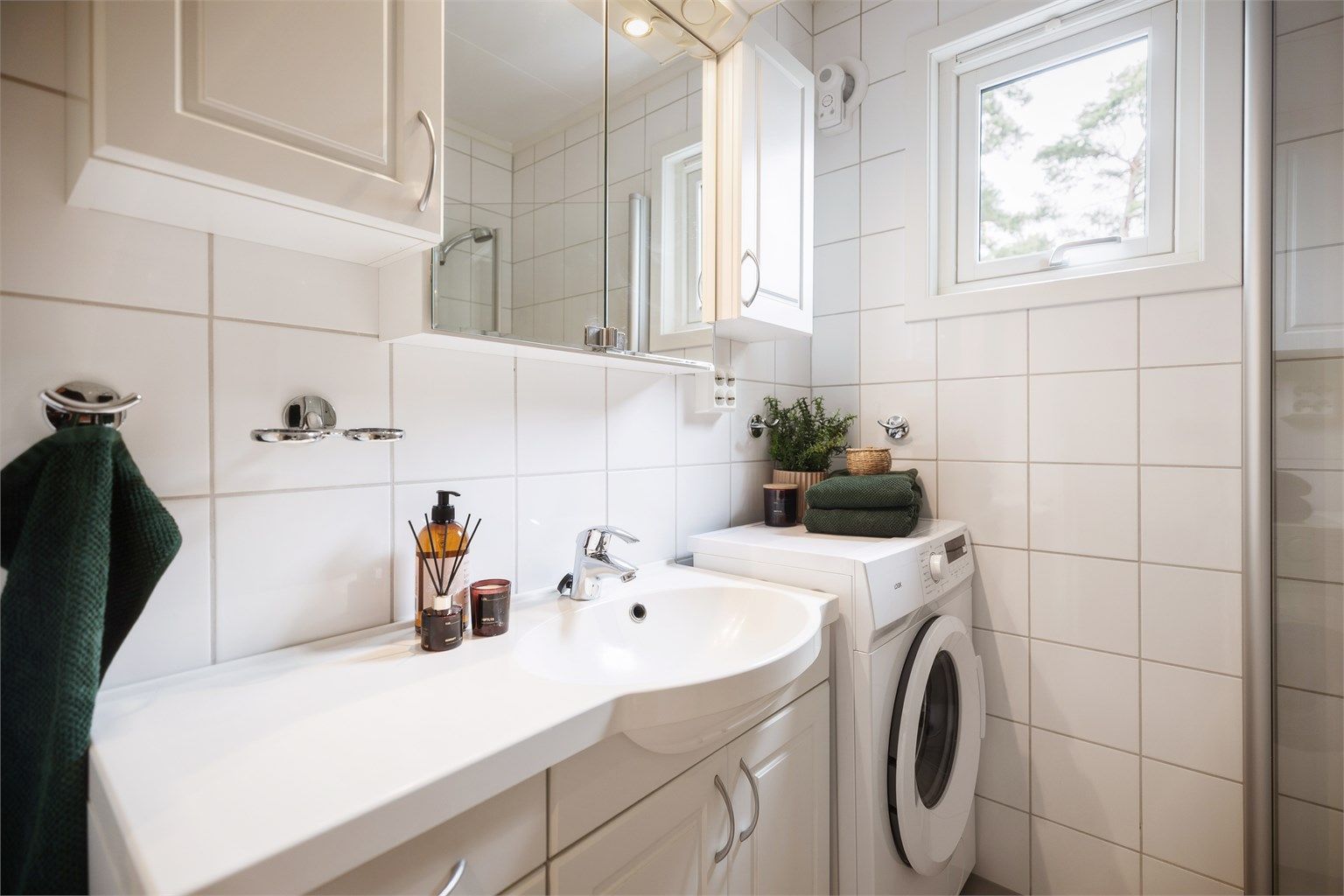 Innredningen består av servant med skap og speilskap med belysning. Det er også praktisk opplegg for både vaskemaskin og tørketrommel.