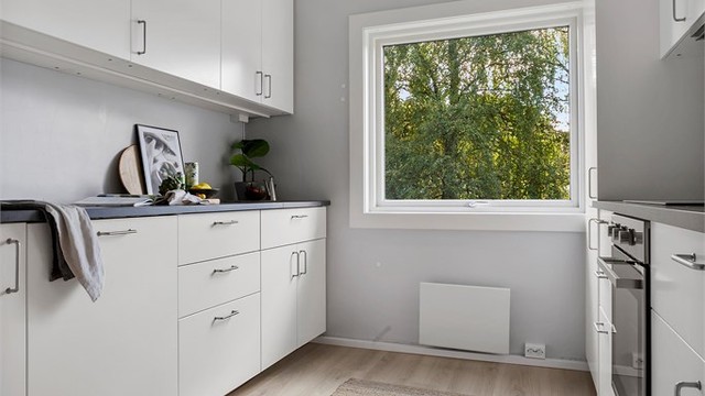 Kjøkkenet ble fornyet i 2025 med hvit innredning fra Ikea og laminat på gulvet.