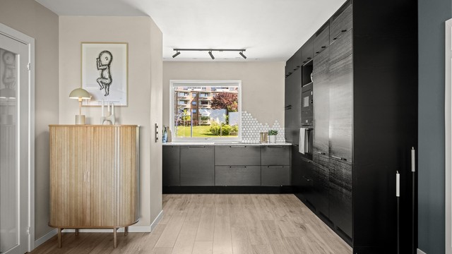 Moderne kjøkken fra Epoq (2021) med slette, mørke fronter og laminat benkeplate.