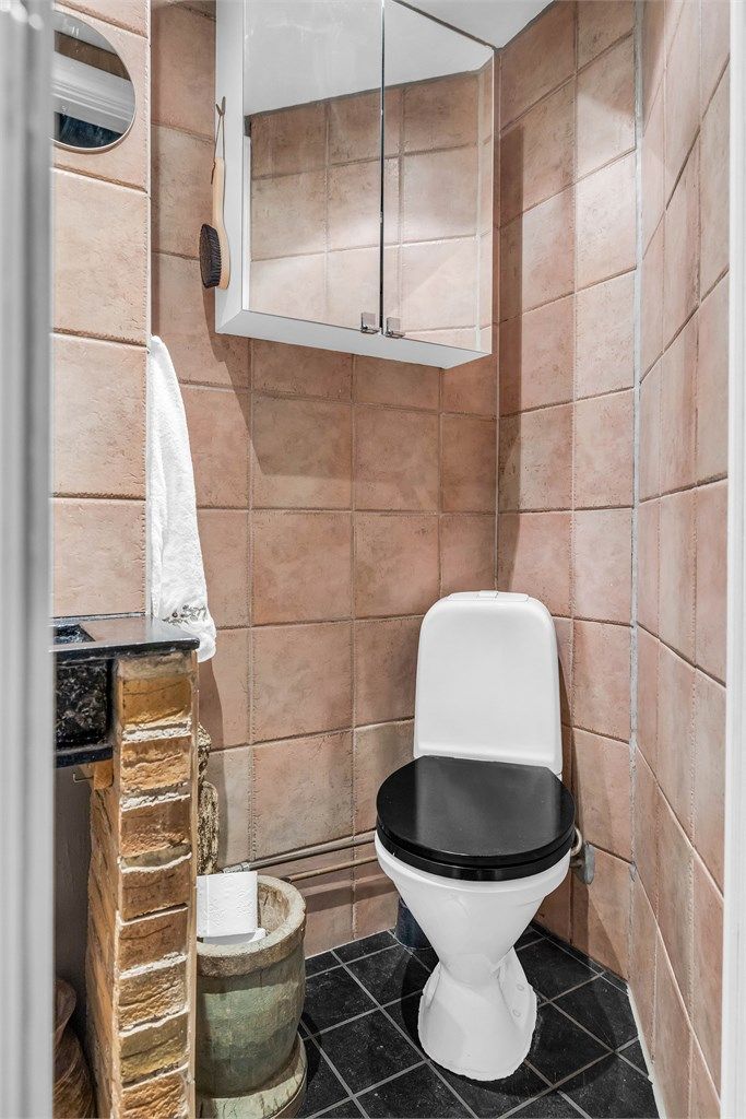 Flislagt baderom med dusj, toalett og servant.