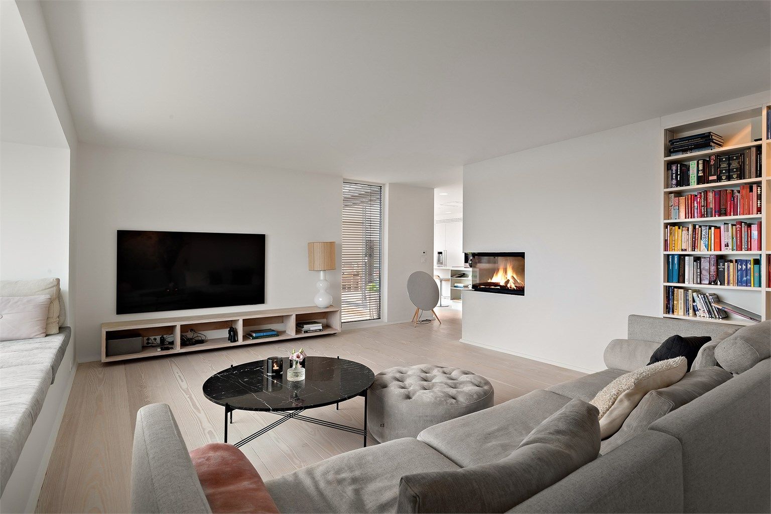 Stue med lyse overflater og plass til sofagruppe og Bunner peis