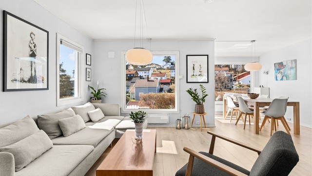 Den delvis åpne løsningen binder stue, spisestue og kjøkken sammen til en sosial og funksjonell sone.