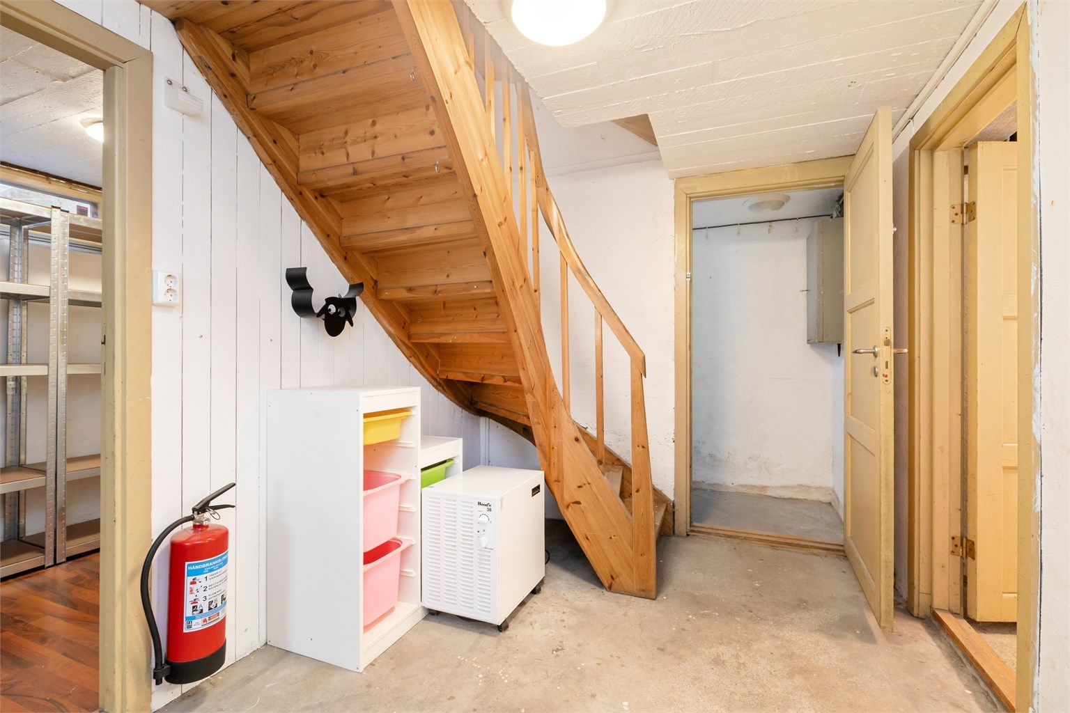 Trappegang i kjelleren med støpt betonggulv og adkomst til boder.