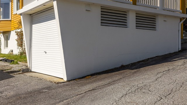 I underetasjen er det en integrert garasje med vippeport i tre