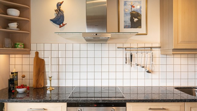 Kjøkkenet er utstyrt med integrert stekeovn, platetopp og en vegghengt ventilator i stål.