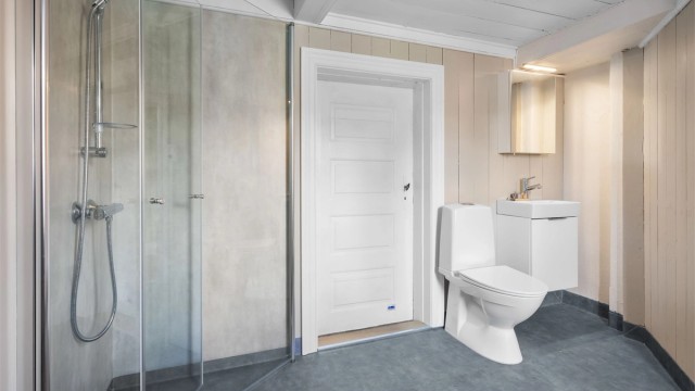 Badet er innredet med toalett og servant med underskap.
