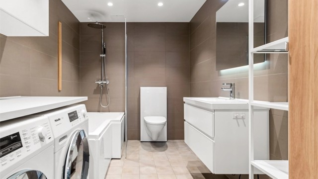 Moderne og flislagt baderom fra 2022 med gulvvarme og downlights. Opplegg for vaskemaskin og tørketrommel