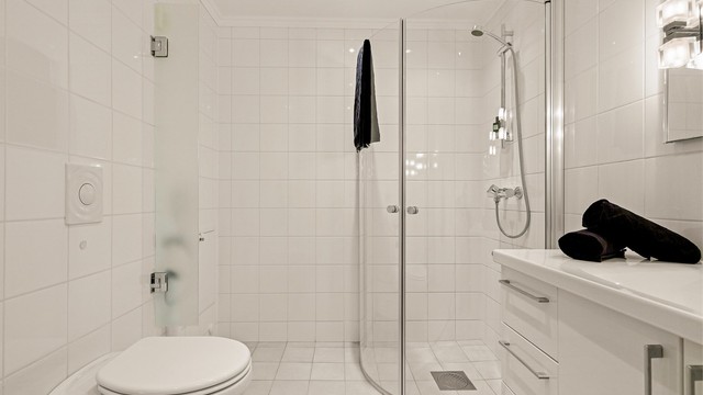 Badet er utstyrt med vegghengt toalett og dusjhjørne med innfellbare glassdører - som gjør badet mer romslig.