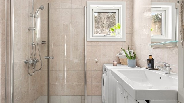 Flislagt bad med varmekabler i gulvet for ekstra komfort.