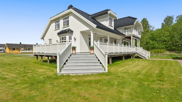 Eneboligen har trekledning og tak tekket med glassert takstein.