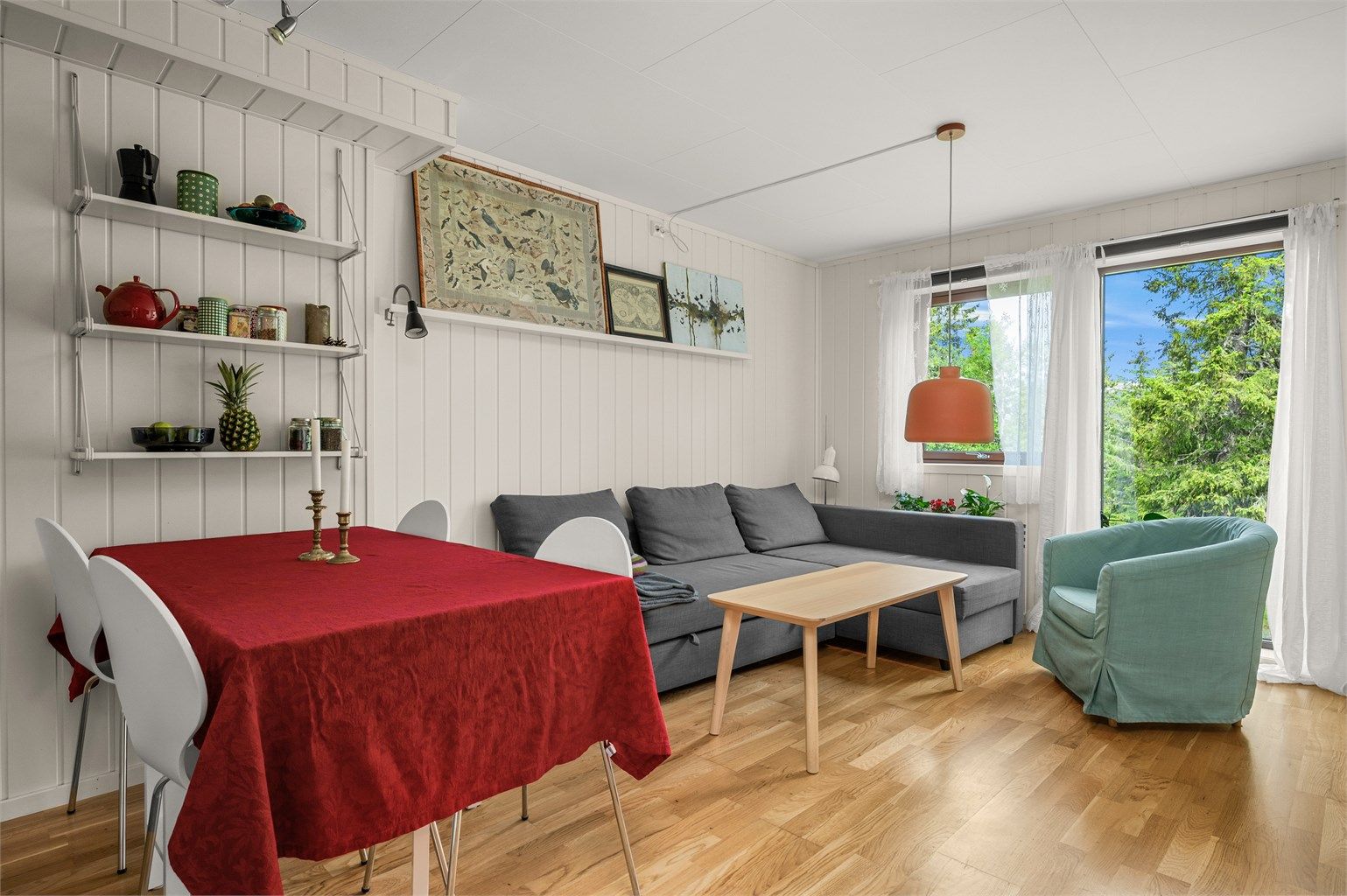 Lys og trivelig stue med plass til både sofagruppe og spisebord, samt utgang til utearealet.