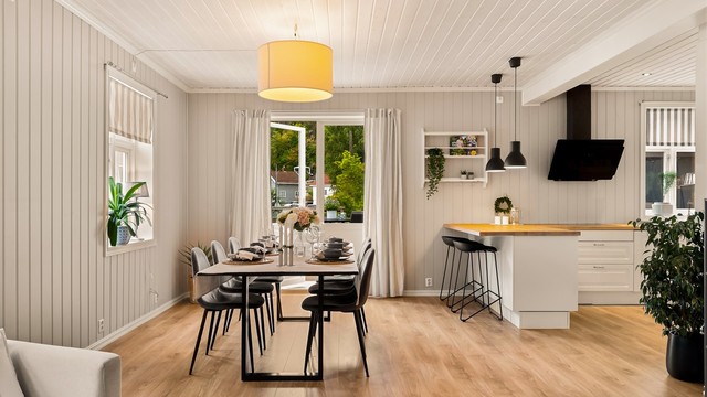 Stua er delt i flere soner, nærmest kjøkkenet er det spiseplass og utgang til terrassen.