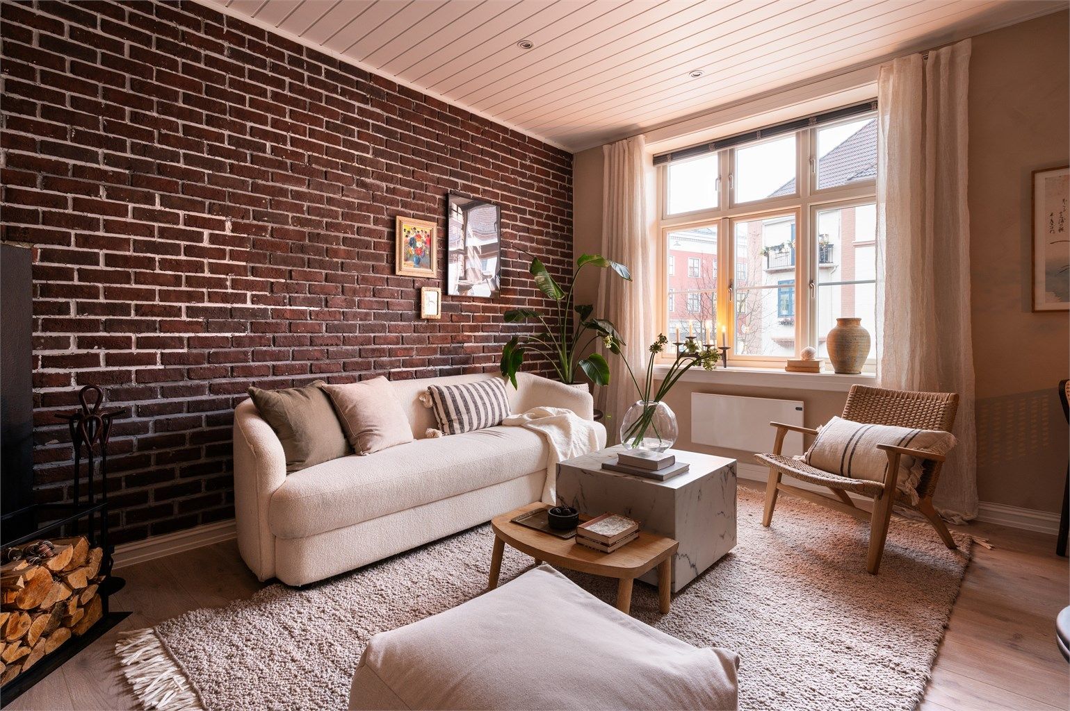 Stuen er malt i en behagelig farge på vegg, som står i fin kontrast til teglstensveggen