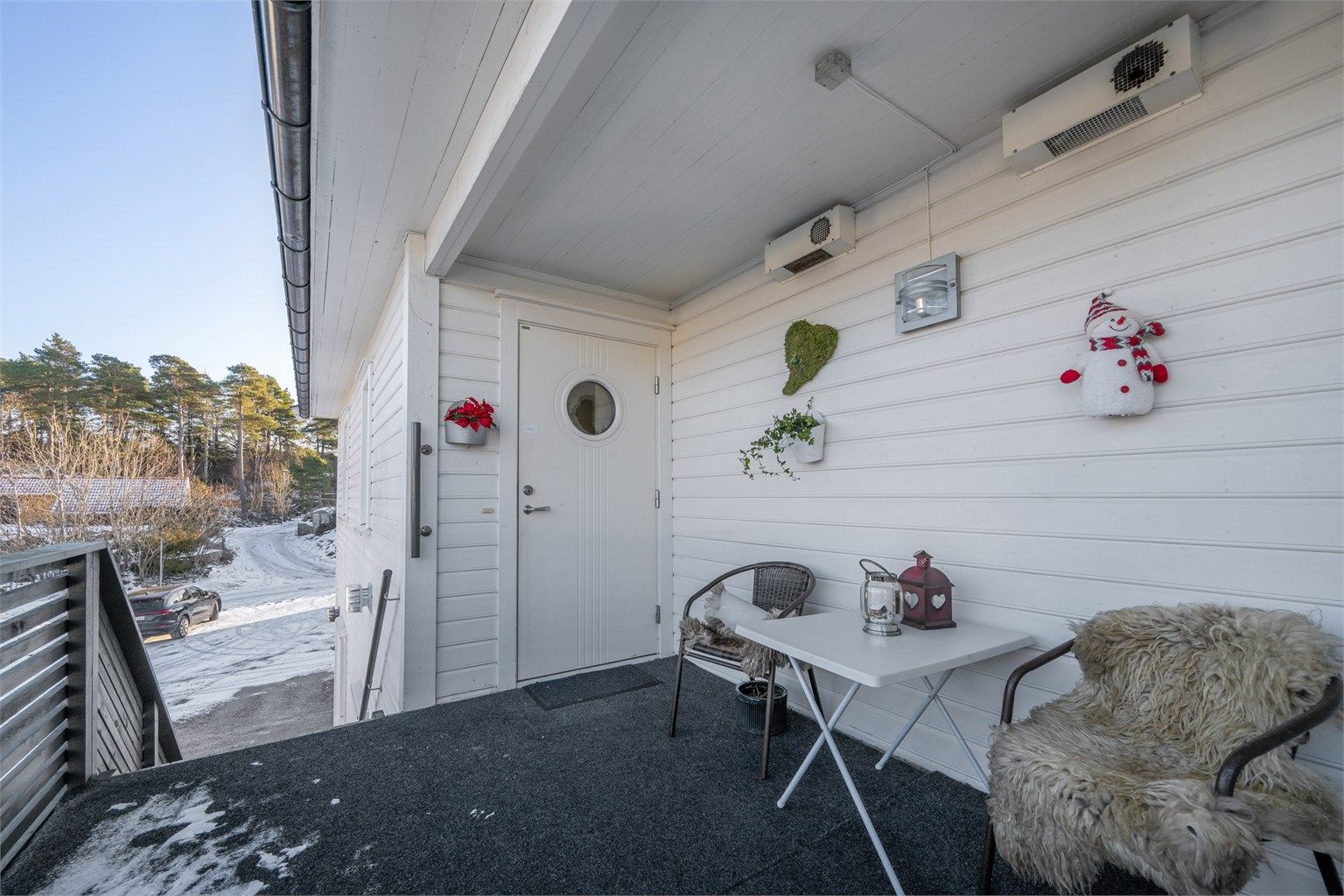 Overbygget inngangsparti med lys. 