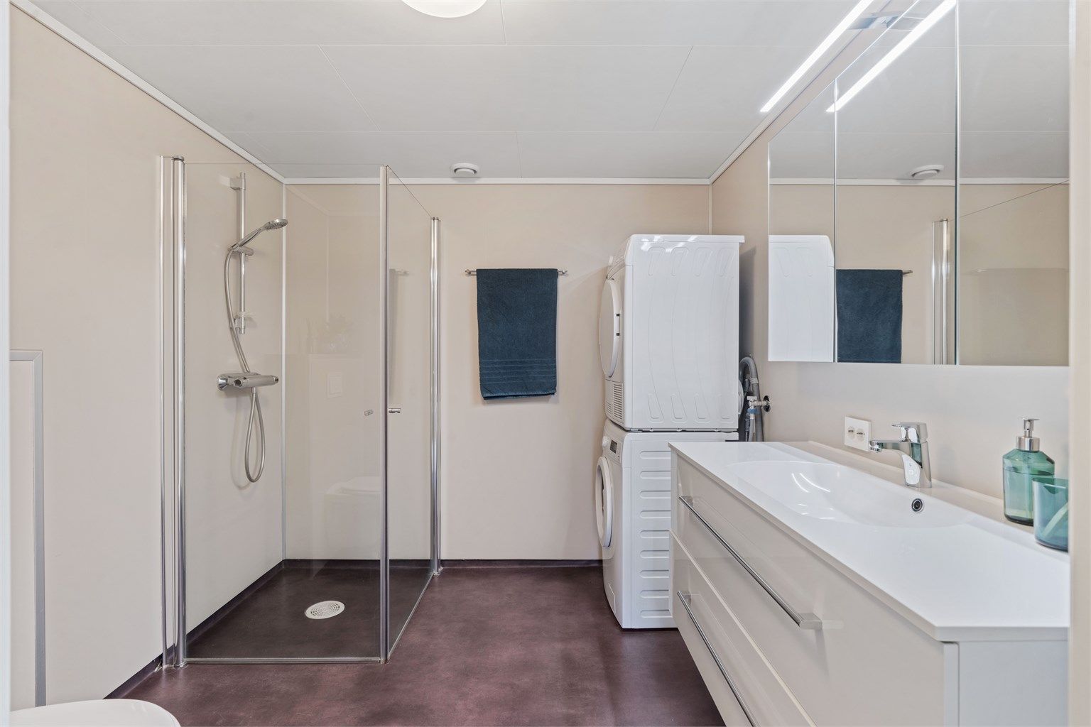Bad med gulvvarme og opplegg for vaskemaskin og tørketrommel.